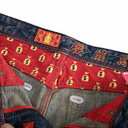 Close-up of the interior waistband and lining of a pair of jeans. The waistband is dark blue denim with red embroidered Chinese characters and a small red label.