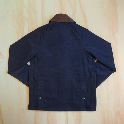Back view of the navy corduroy hunting jacket showing raglan sleeves and rear hem snaps.