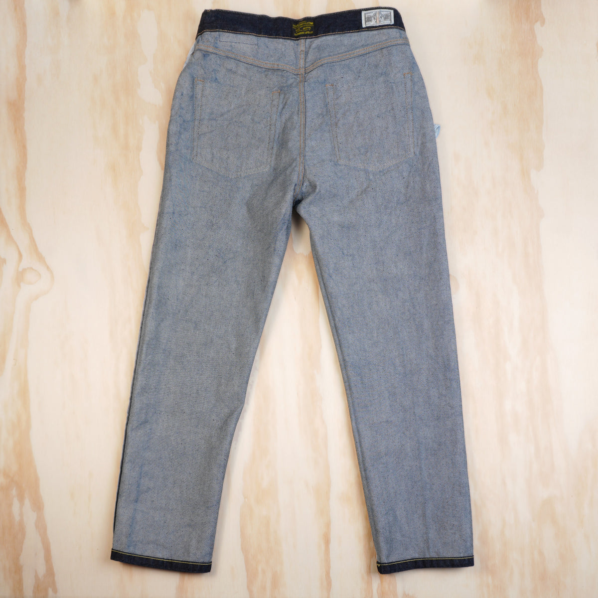 Inside back of OKONKWO jeans showing denim weave, seams and waistband