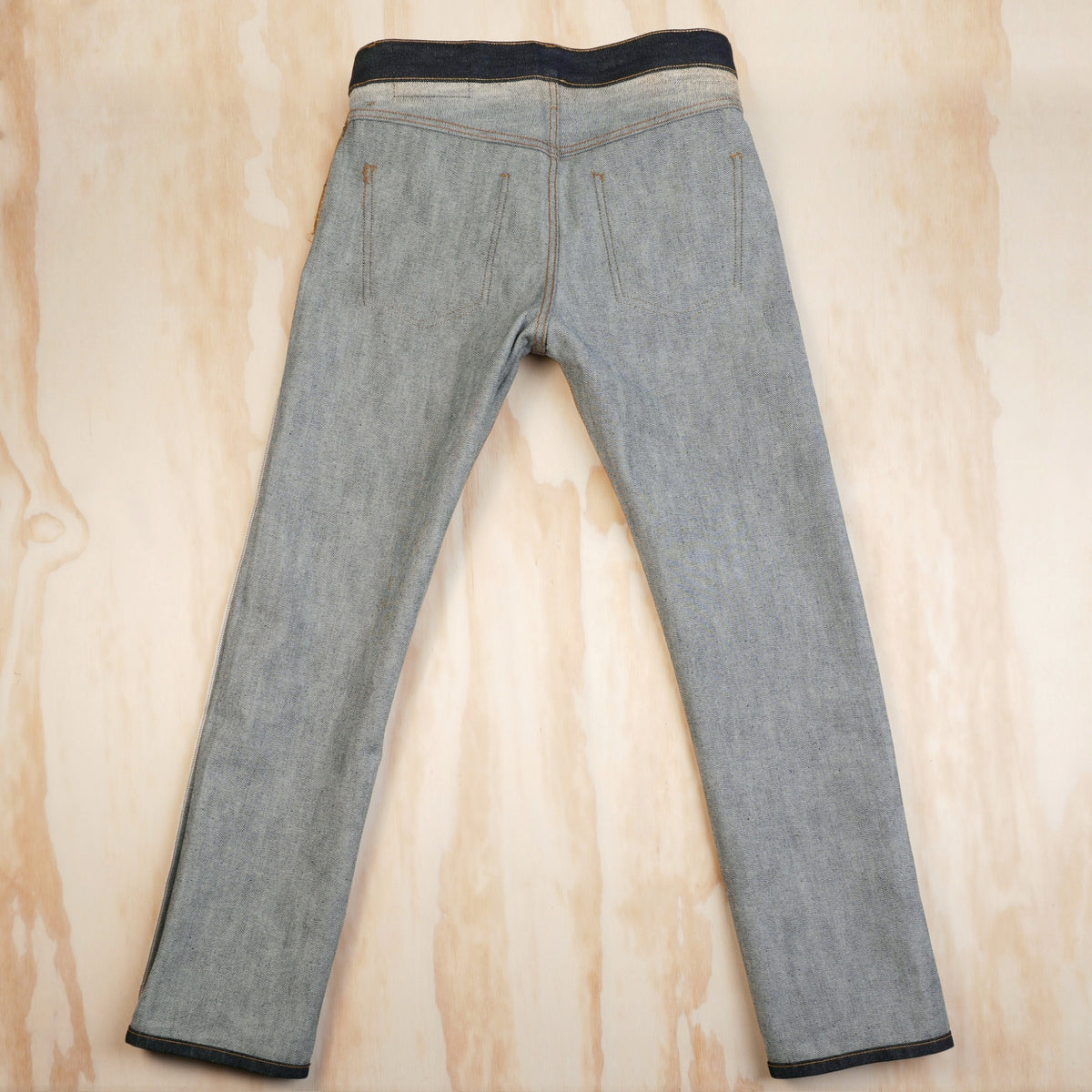Inside-back view of the jeans showing the reverse of the denim and enclosed seams.